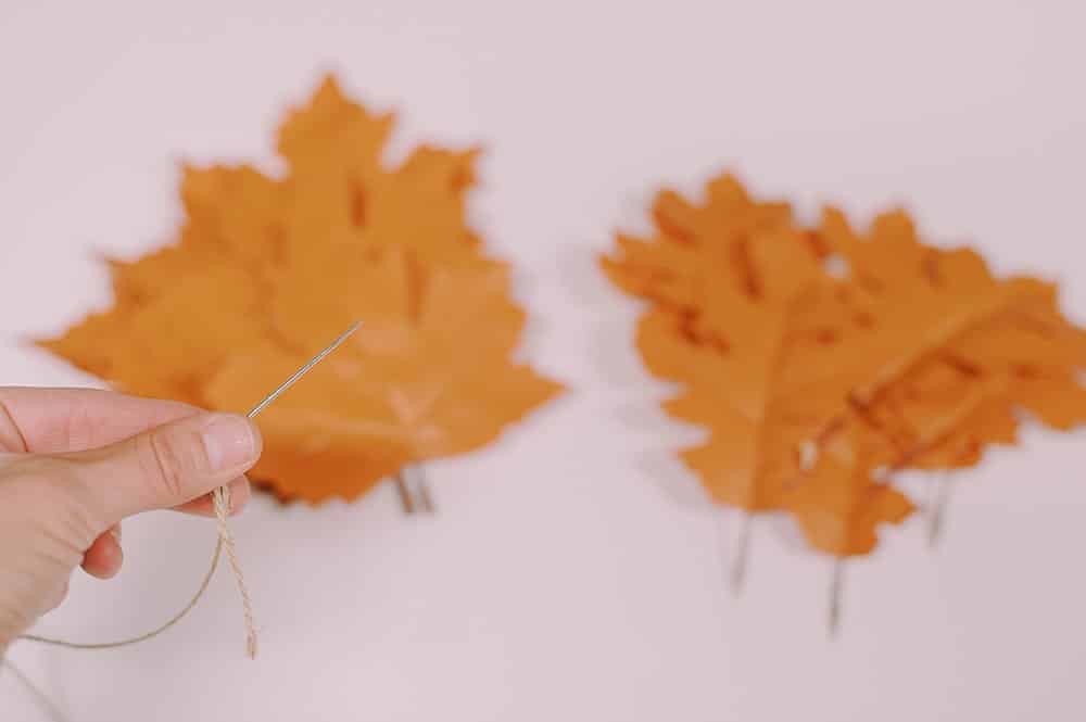 use an embroidery needle to thread twine for the leather leaf garland