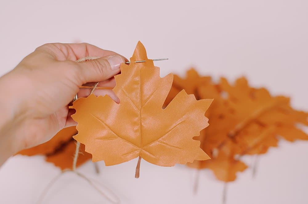 string needle through top of leather leaf