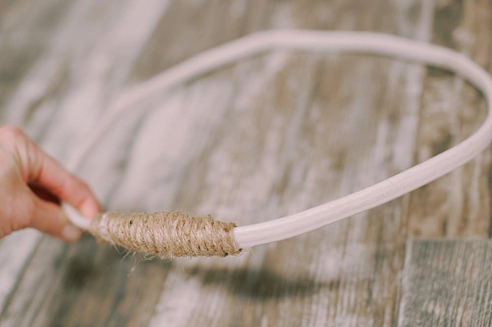 Old electrical wire formed into a circle with the ends taped together and wrapped in twine.