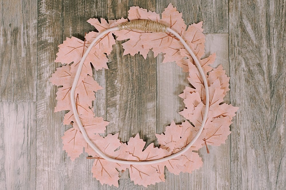 The back side of a wreath made of faux leather leaves.
