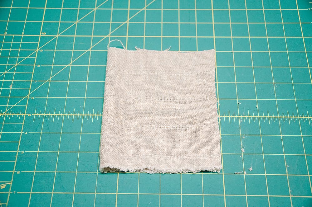 Fabric folded in half on a sewing cutting mat.