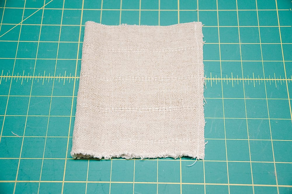 Linen fabric that is sewn along one side to make a fabric tube in preparation to make DIY fabric pumpkins.