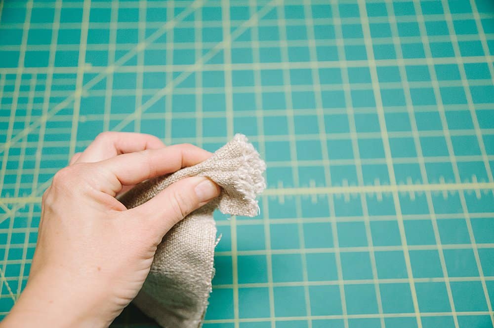 Pinching the fabric together in an accordion shape.