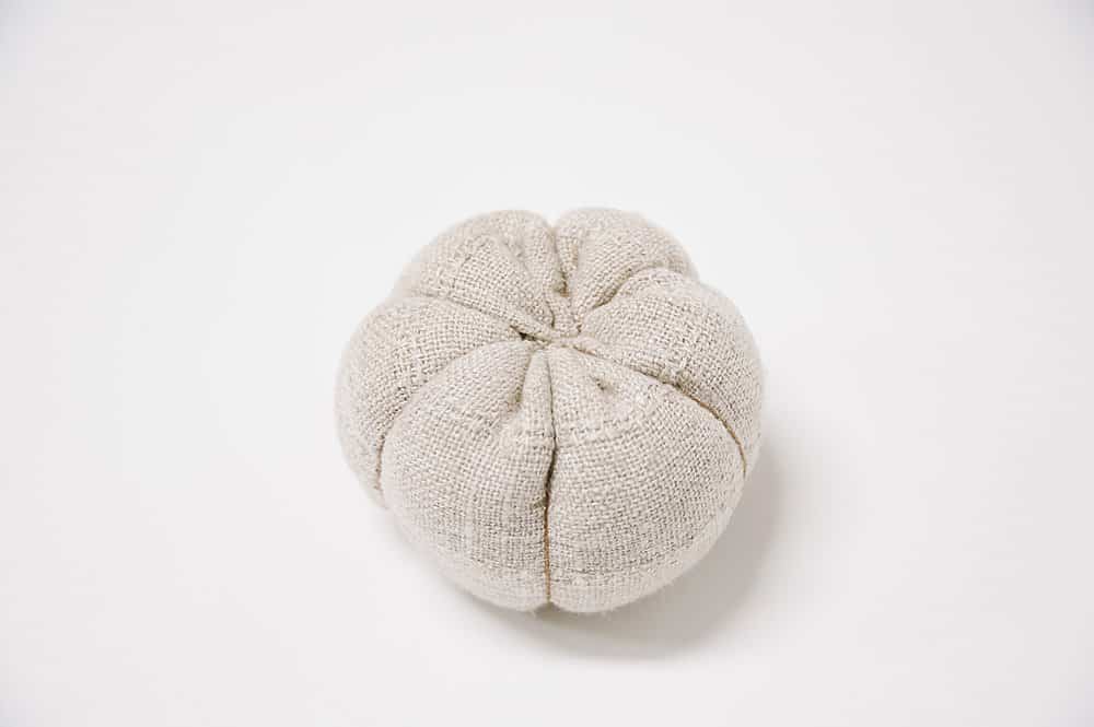 A fabric pumpkin body ready for the wooden stem to be hot glued on.