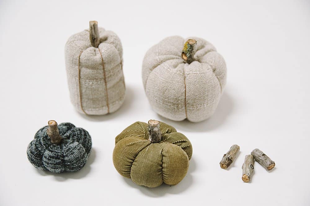 Fabric pumpkins with small pieces of wooden sticks as the stem.