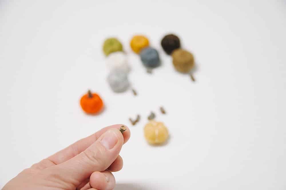 hot glue a tiny piece of wooden branch to top of felt pumpkin