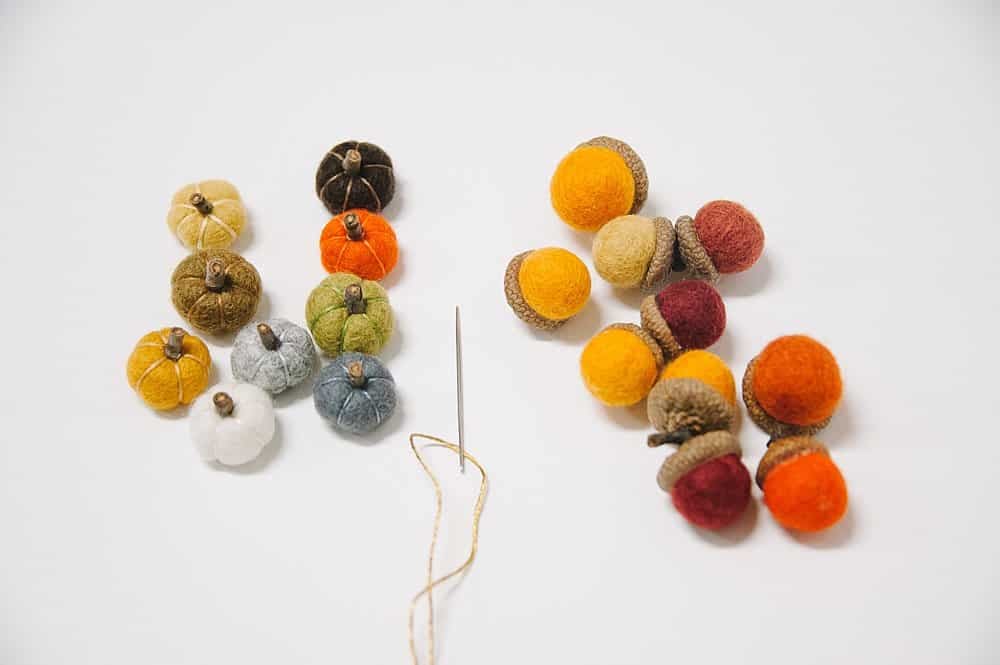 A needle and thread to string felt ball pumpkin and felt acorns into a fall garland.