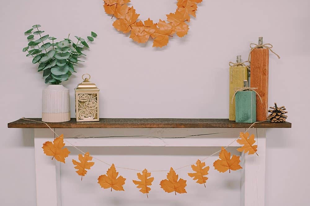 Wooden pumpkins on a fireplace mantel.