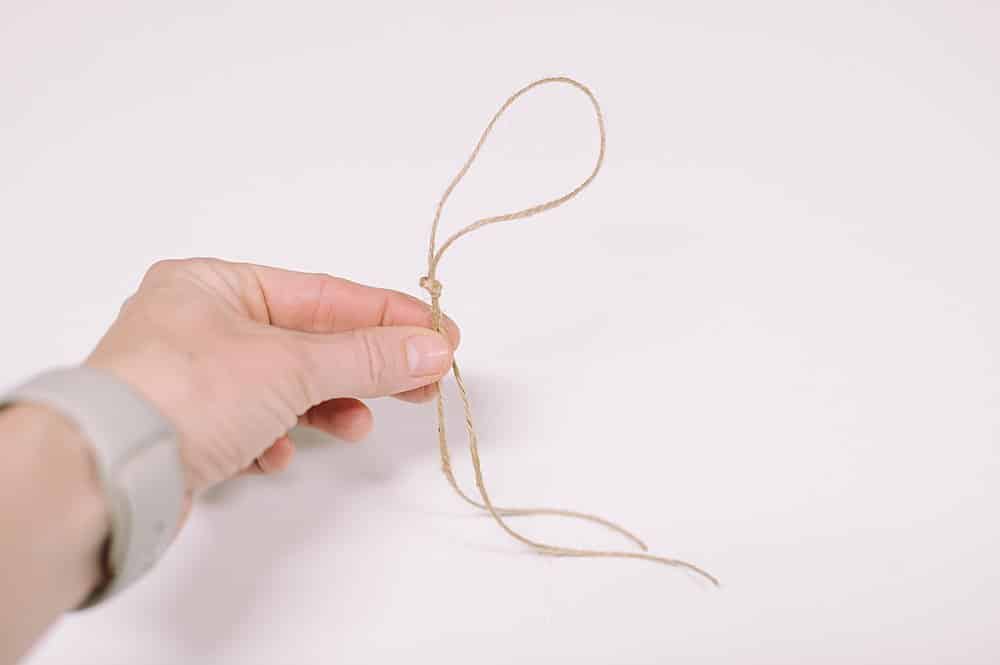 fold twine in half and tie a knot and a hanging loop