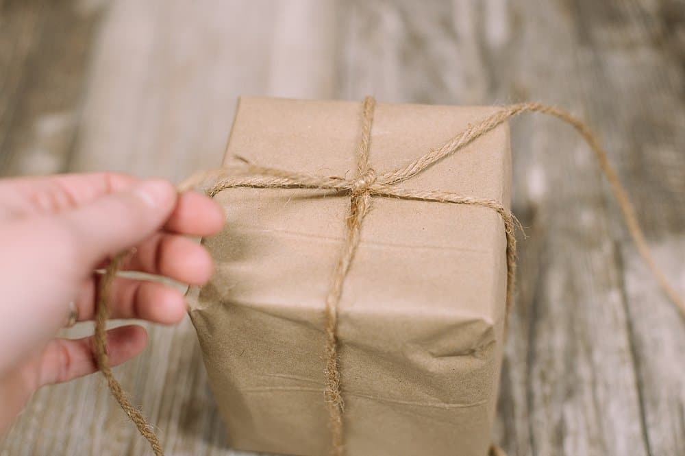 tying a kraft paper wrapped gift with jute twine