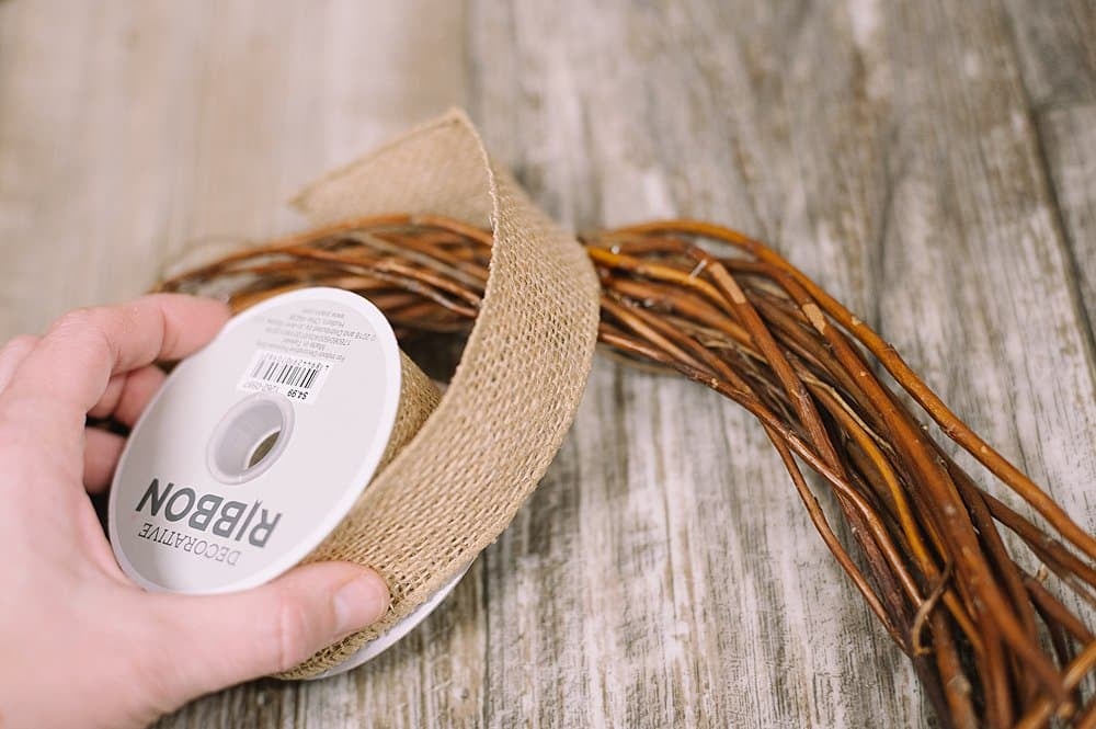 Wrap burlap ribbon around a grapevine wreath form.