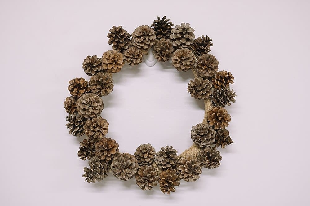 A pinecone wreath with a few bare spots.