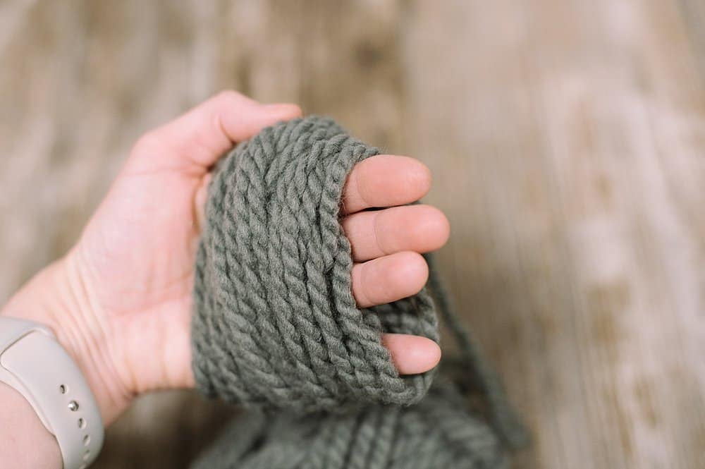 Yarn wrapped around a hand to make a yarn tassel.