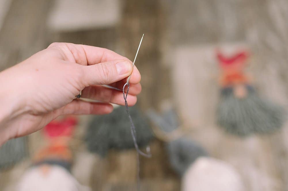 Embroidery floss threaded into a needle.