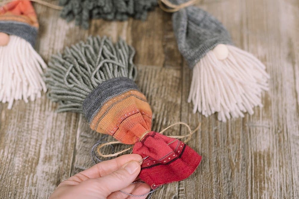 Thread embroidery floss through the back of the sock gnome's hat.