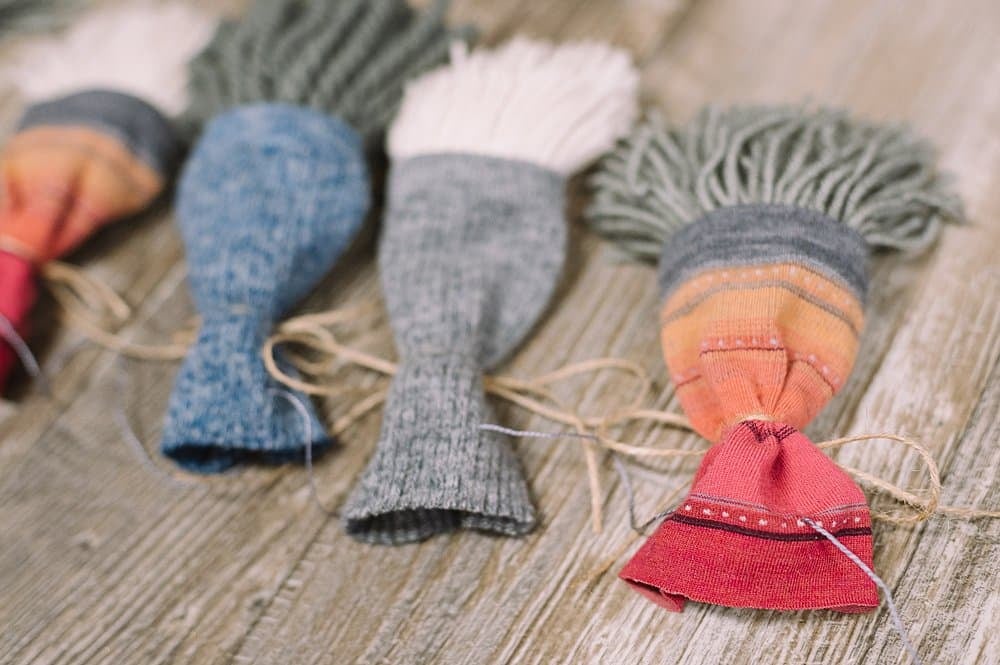 Embroidery floss strung through the back of gnome's hats to create a garland.