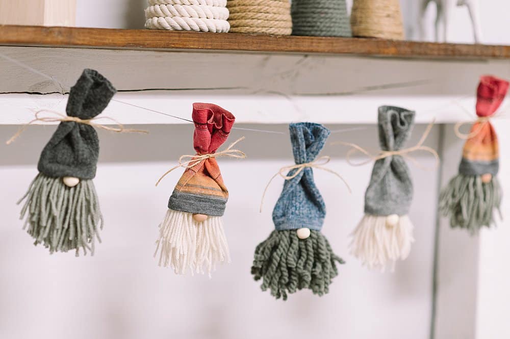 how to make a diy gnome garland for Christmas using yarn and sock gnomes