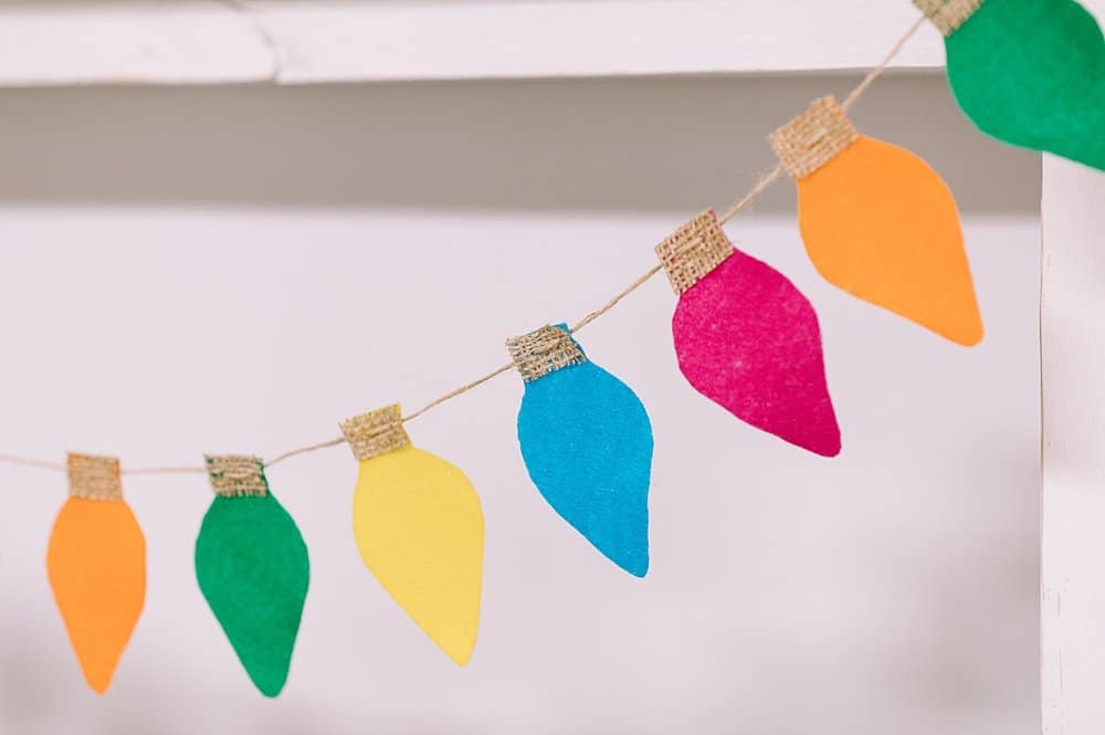 Colorful felt lightbulbs hanging on a garland.