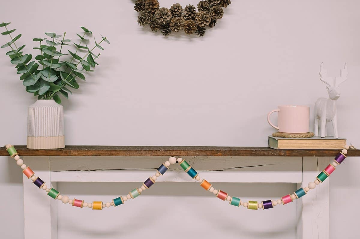 A DIY Colorful Garland made with Vintage Wooden Spools of Thread and Wood Beads.