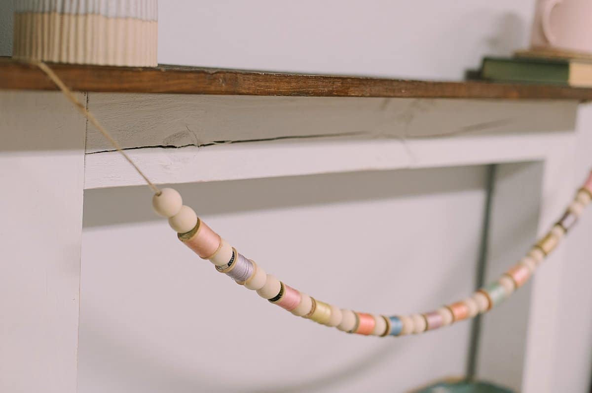 how to make a garland for spring using wood beads and vintage wooden spools of thread