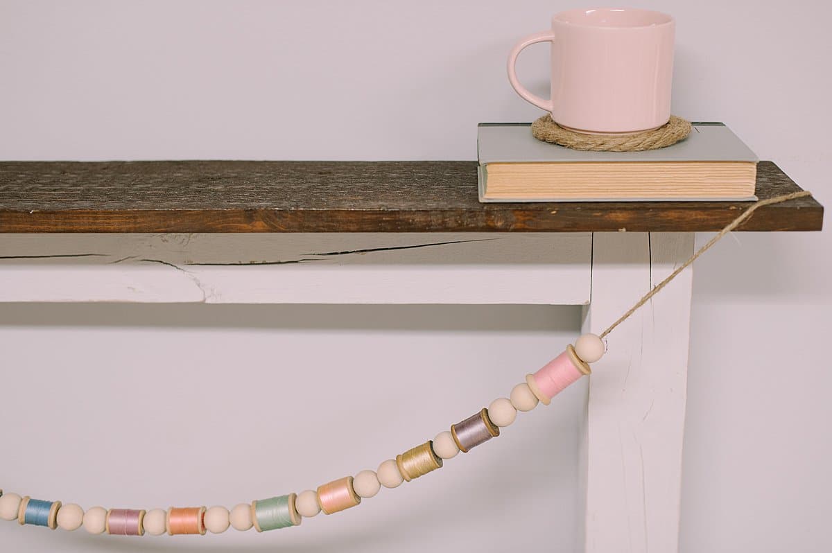how to make a garland for spring using wood beads and vintage wooden spools of thread