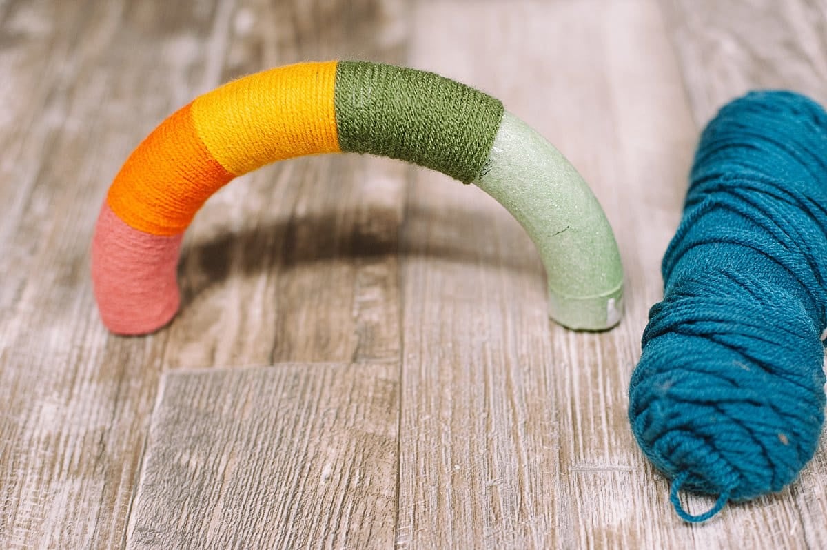 Continue wrapping the yarn around the rainbow styrofoam arch