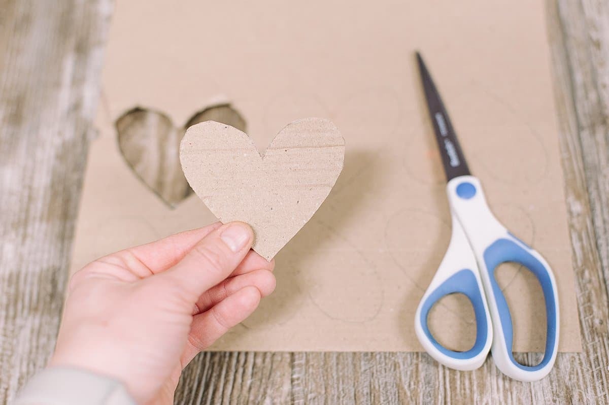 Cut out heart shapes on cardboard.
