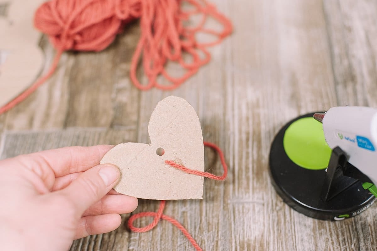 hot glue one end of yarn to cardboard heart