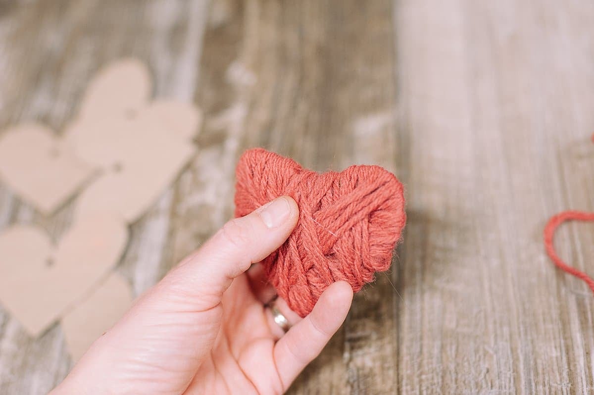 Hot glue end of yarn to the back of the heart.
