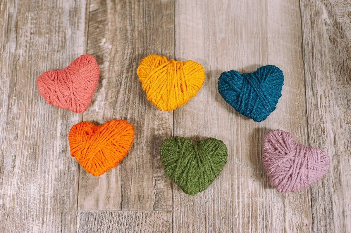 Yarn wrapped hearts in rainbow yarn colors.