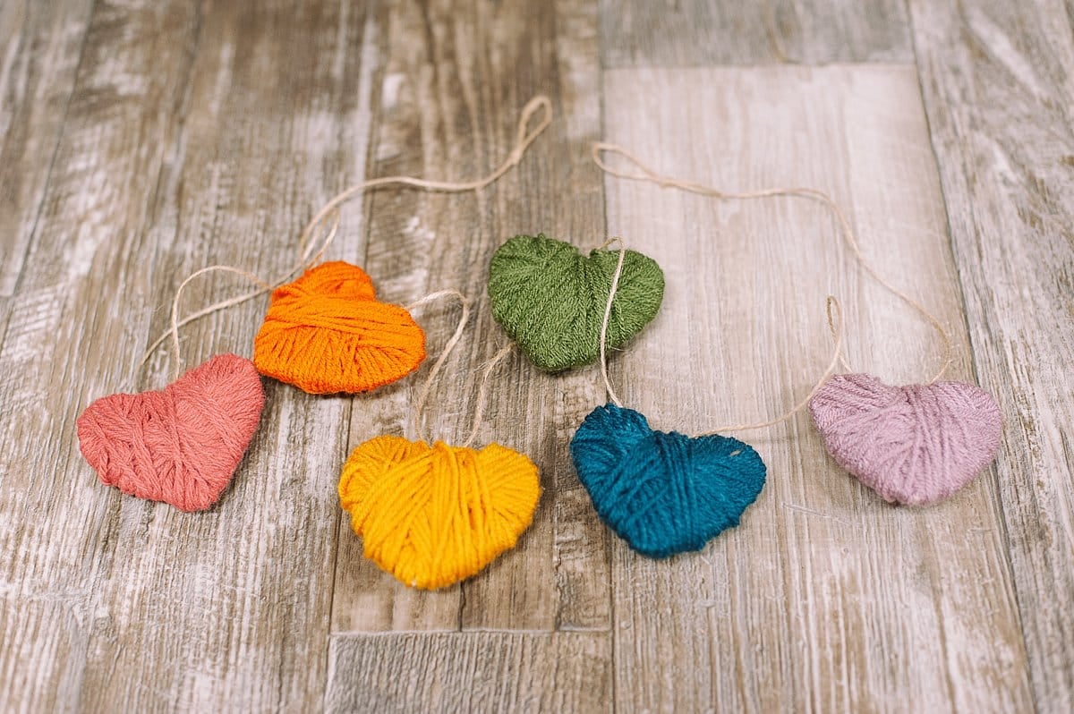 Thread all of the yarn-wrapped hearts onto the twine hanging string to make a garland.