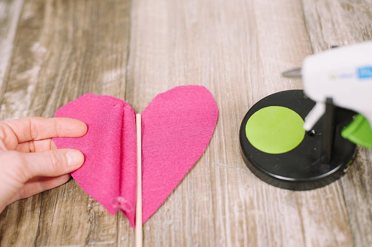 Hot glue a dowel into the felt heart.