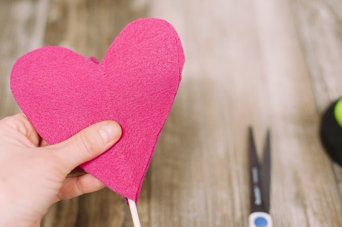 Hot glue the dowel into the felt heart.