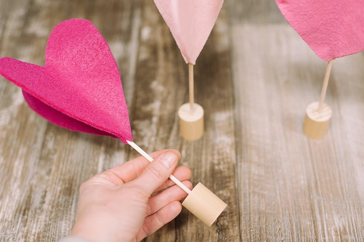 Insert the wooden dowel of the felt heart into the wooden base.