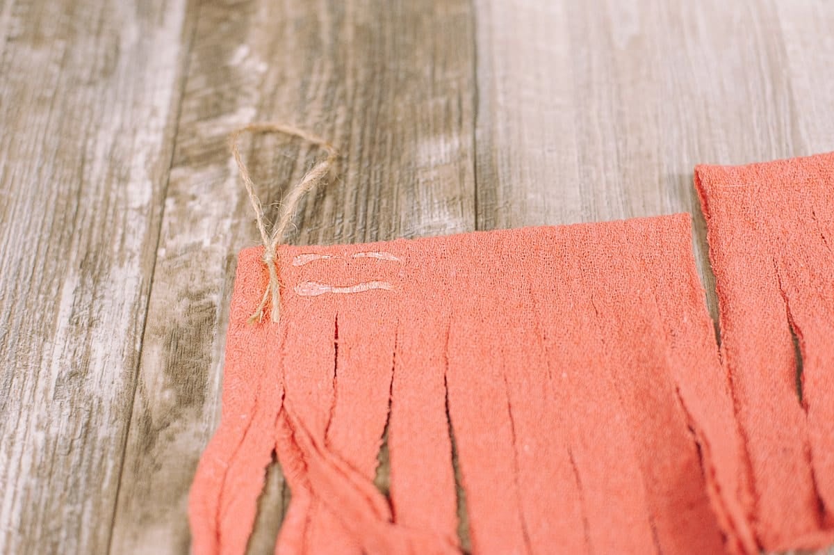 add twine into the fabric fringe tassel