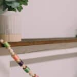 How to make a colorful garland with wood beads and thread spools.