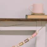How to make a spring garland with wooden beads and pastel thread spools.