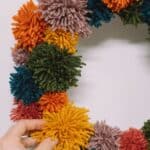 How to make a pom pom wreath using yarn in rainbow colors.