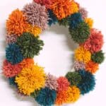 How to make a pom pom wreath using yarn in rainbow colors.