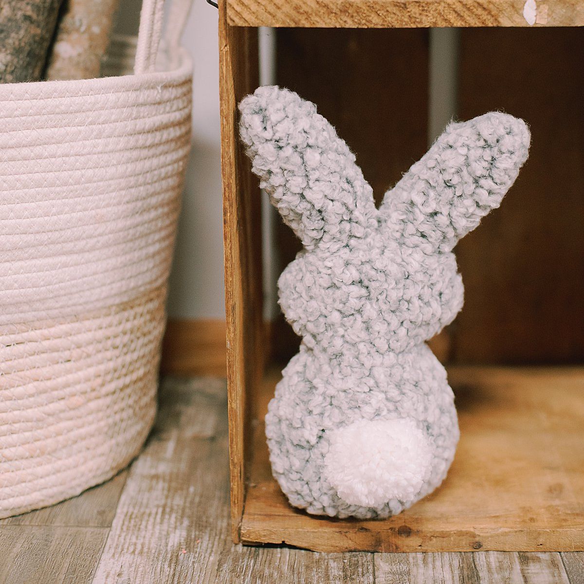 Stuffed bunny rabbit made out of an old fuzzy sweatshirt, with a white yarn pompom for a tail.
