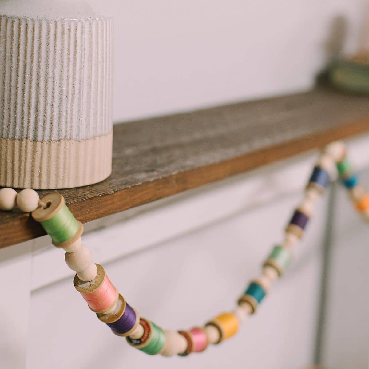 How to make a colorful garland with wood beads and thread spools.