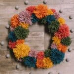 How to make a pom pom wreath using yarn in rainbow colors.