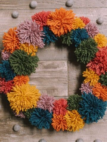 How to make a pom pom wreath using yarn in rainbow colors.