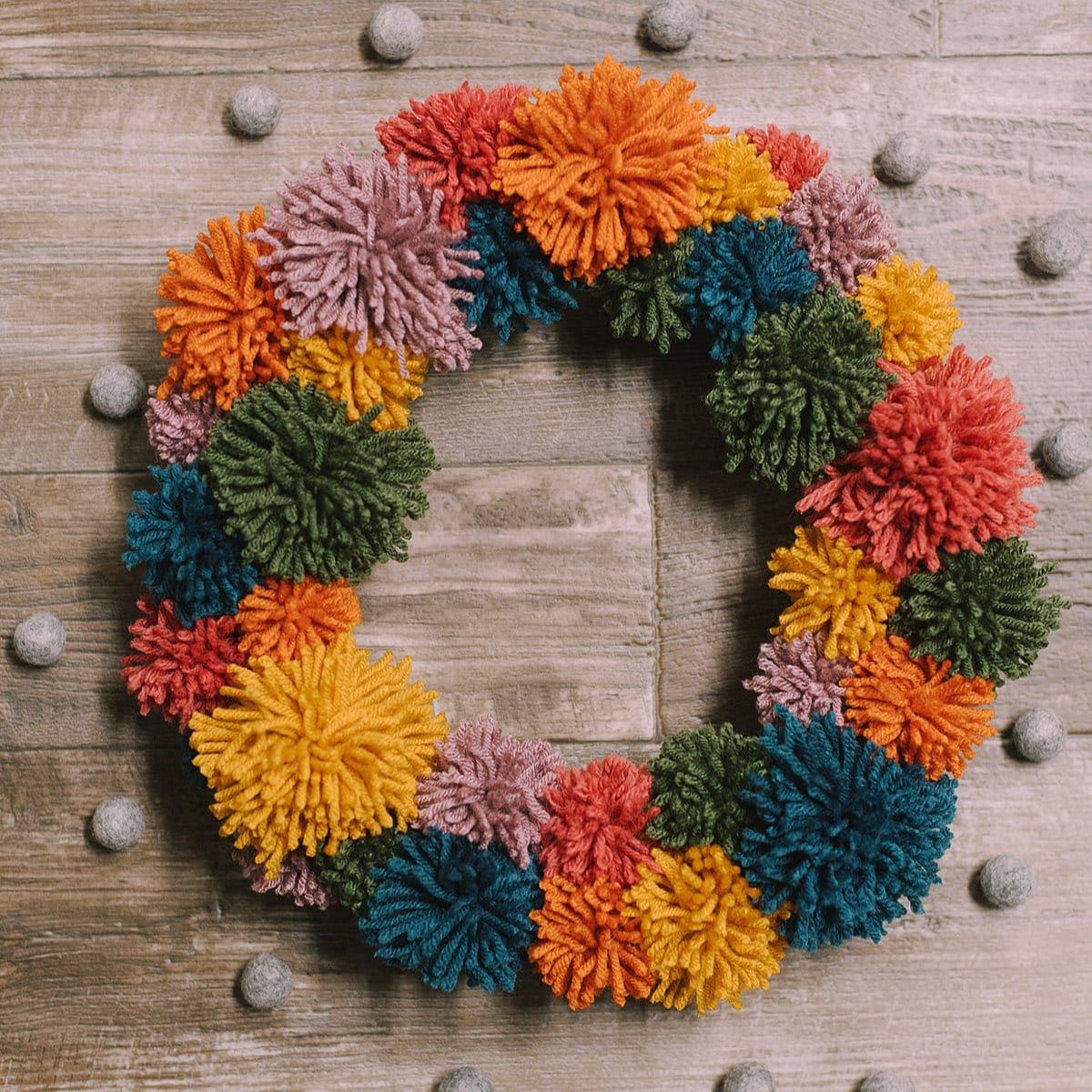 How to make a pom pom wreath using yarn in rainbow colors.