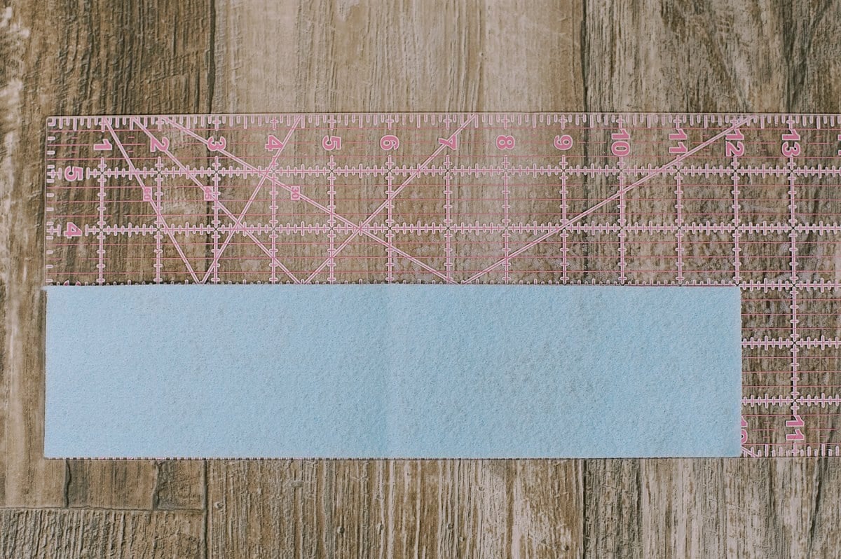 A felt rectangle laying on top of a plastic sewing ruler.