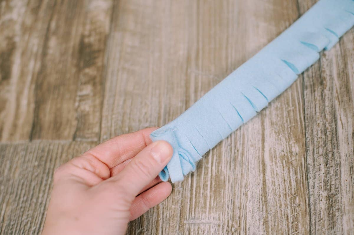 A felt strip beginning to be rolled up and glued in place to make a mum flower.