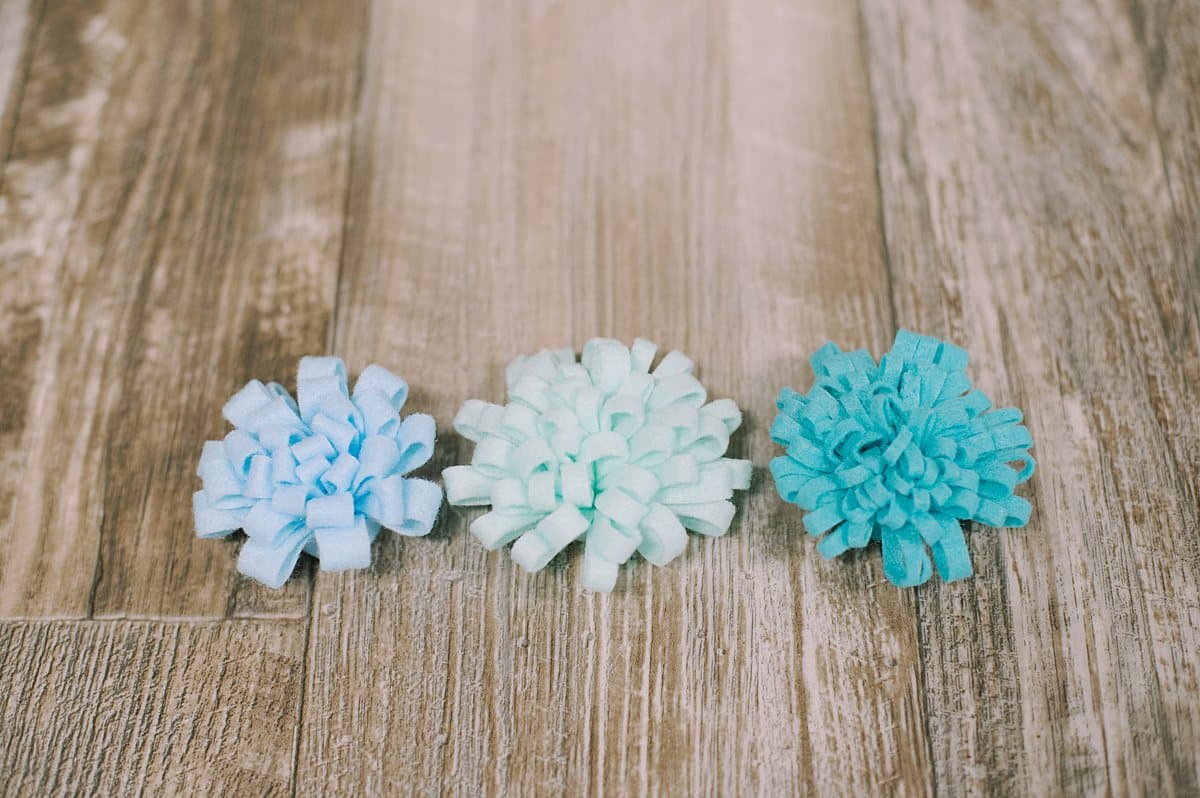 Three variations of mums made from felt, determined by how thick the fringe is cut.