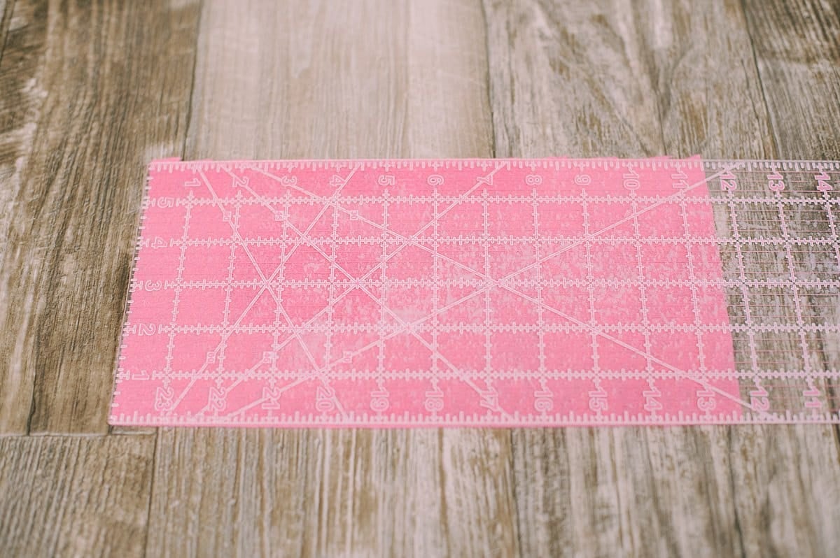 A rectangle of felt with a sewing ruler laying on top of it to measure the dimensions.