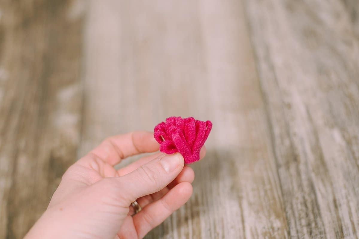 A fringed felt mum held in a hand.