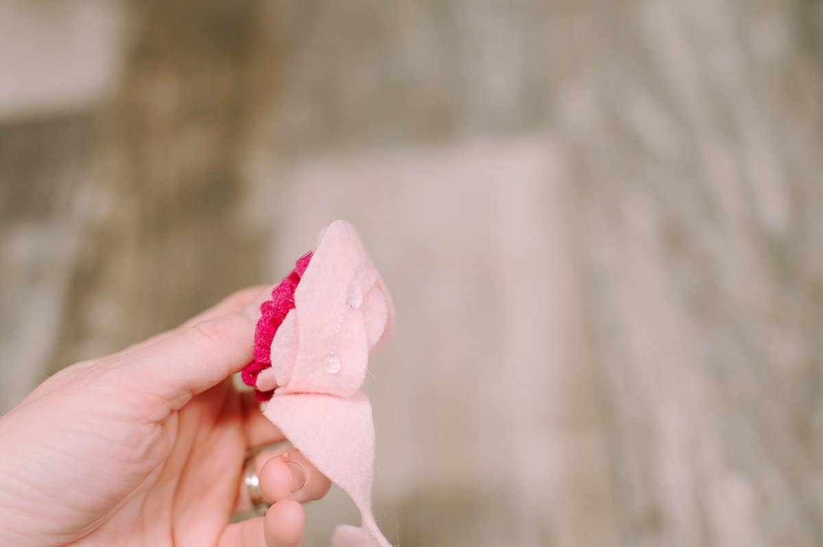 The felt of a rose being hot glued and rolled into shape.